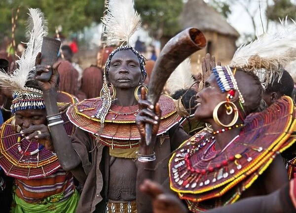 During a Ngetunogh ceremony, the mothers of Pokot initiates sing and dance holding high the cowhorn containers they used to smear fat over the masks of their sons as