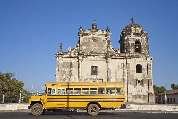 Nicaragua, Leon, American yellow bluebird bus driving past San Juan Church