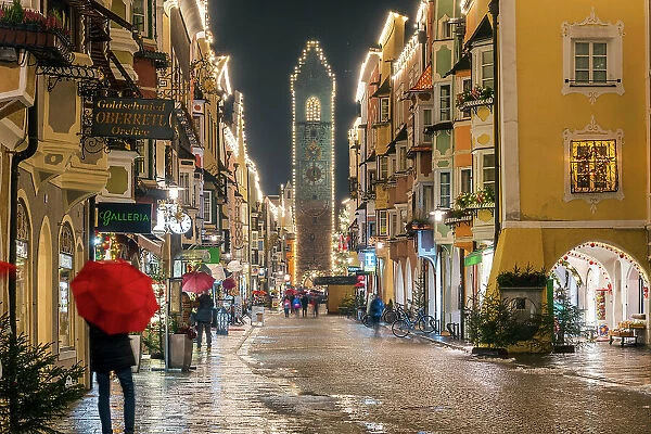 Night view of the main street and Zwolferturm medieval tower decorated with Christmas lights, Sterzing-Vipiteno, South Tyrol, Italy