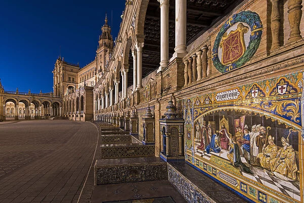 Night view of the tiled Province Alcoves along the walls of the Plaza de Espana, Seville