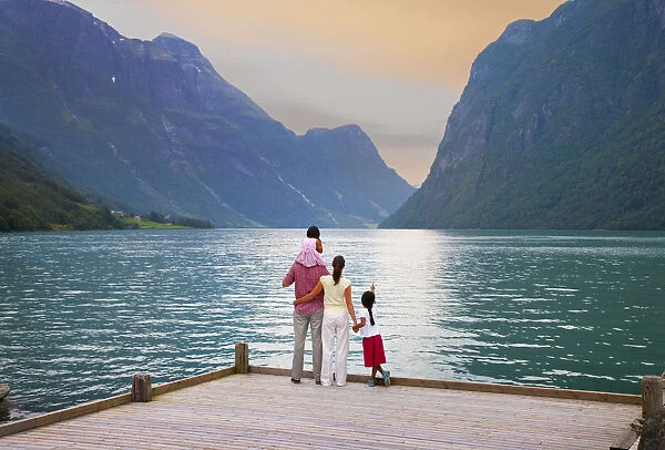 Norway, Western Fjords, Nordfjord, Family standing on jetty at dusk (MR)