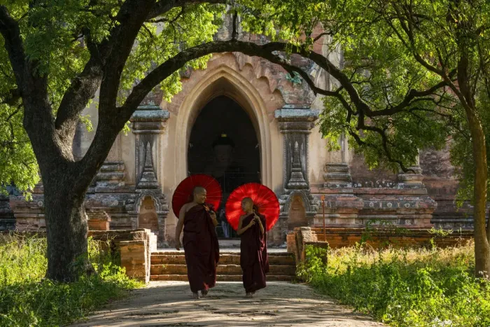Framed Print : Two novice Buddhist monks with red umbrellas walking away from temple, Bagan Framed Print : Two novice Buddhist monks with red umbrellas walking away from temple, Bagan