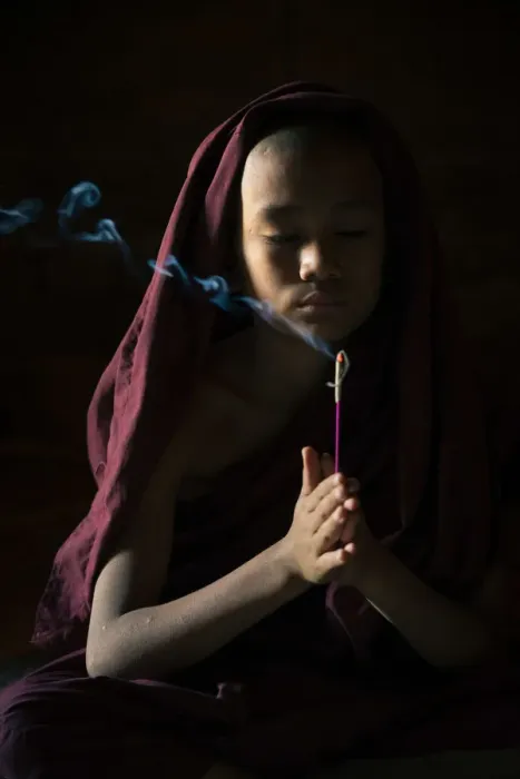 Framed Print : Novice monk holding a lit incense stick while praying inside a temple, UNESCO, Bagan Framed Print : Novice monk holding a lit incense stick while praying inside a temple, UNESCO, Bagan
