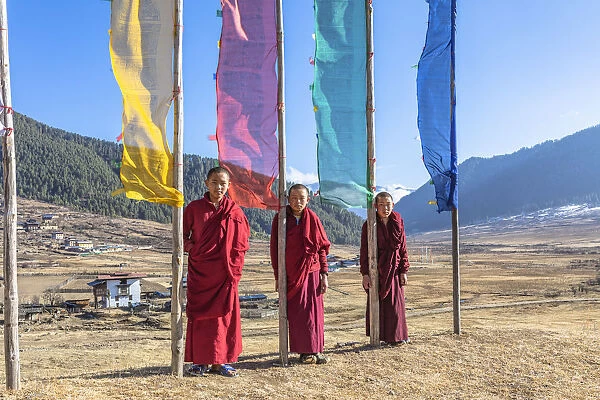 Novice Monks (Child Monks) standing in front of prayer flags in Phobjikha Valley, Bhutan