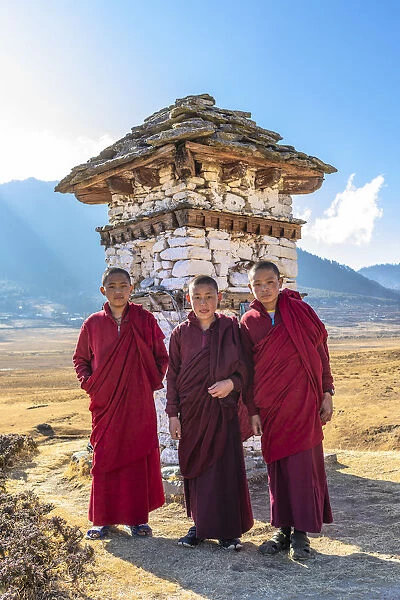 Novice Monks (Child Monks) standing in front of a stupa in Phobjikha Valley, Bhutan
