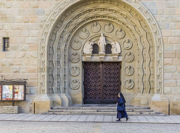 A nun walking past the Cathedral of St. Nicholas in Bielsko Biala, Silesian Voivodeship