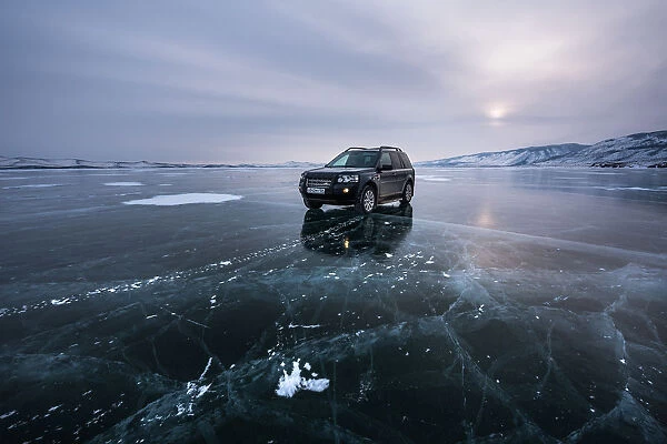 An offroad car over a flat ice at the lake Baikal, Irkutsk region, Siberia, Russia