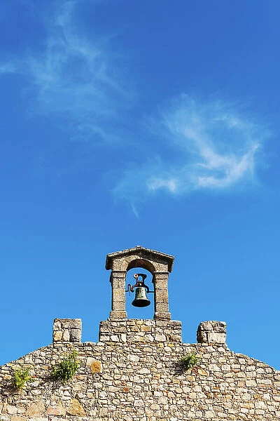 Old bell on top of the stone wall in Castillo de Trujillo (Trujillo Castle), Extremadura, Caceres, Spain