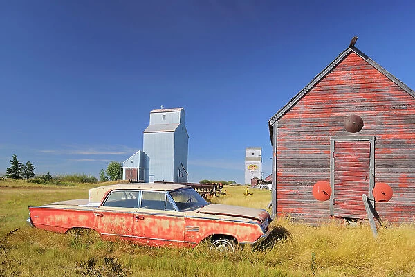 Old car, grain elevator and sheds Darcy Saskatchewan, Canada