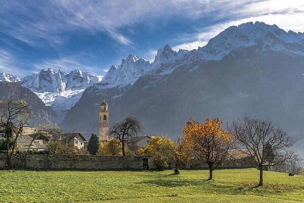 Old church and snowcapped Sciore mountains in autumn, Soglio, Val Bregaglia, Graubunden canton, Switzerland