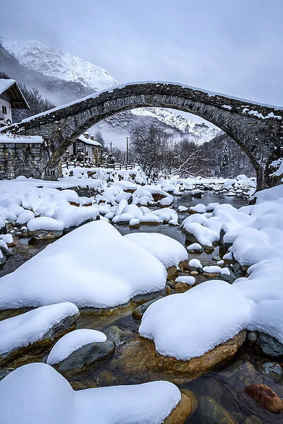 Old (stone, Romanesque) bridge with snow, Fondo, Valchiusella, Piedmont, Italy, Europe