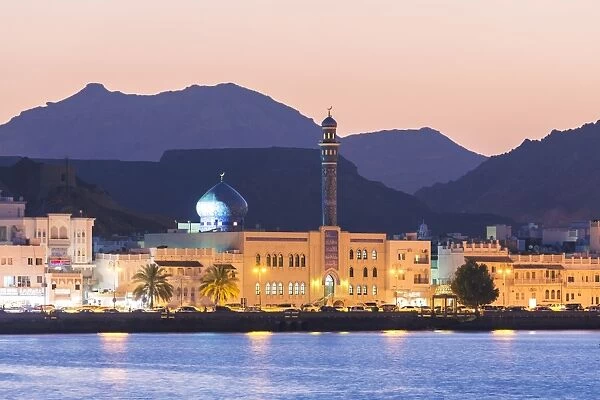 Oman, Muscat. Mutrah harbour and old town at dusk