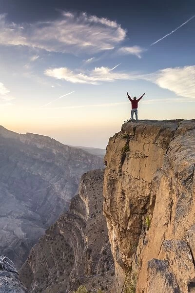 Oman, Wadi Ghul, Jebel Shams. The Grand canyon of Oman, tourist on the edge looking at view