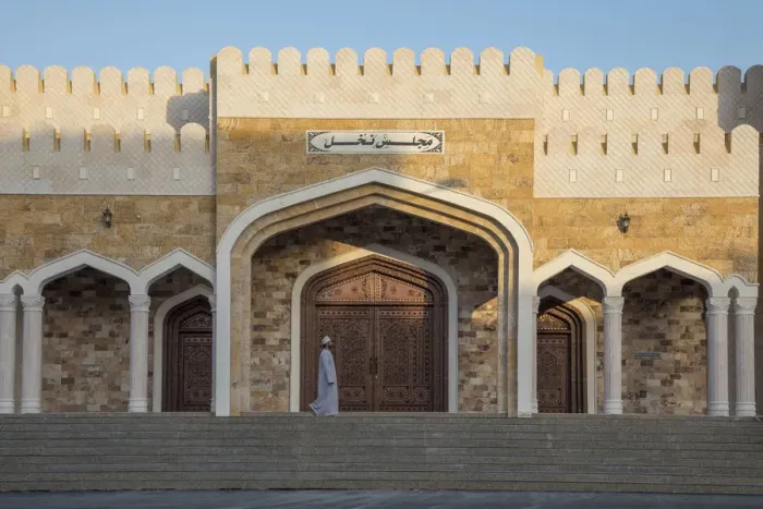 Framed Print : An Omani man walks in front of an ornate house in the village of Nakhal, Al-Batinah Framed Print : An Omani man walks in front of an ornate house in the village of Nakhal, Al-Batinah