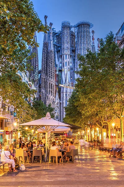 Outdoor cafe at Avinguda de Gaudi pedestrian mall with Sagrada Familia basilica church in