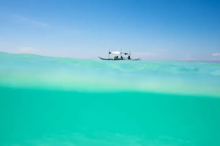 Framed Print : Over-under shot of Philippine outrigger boat in turquoise ocean water off the coast Framed Print : Over-under shot of Philippine outrigger boat in turquoise ocean water off the coast