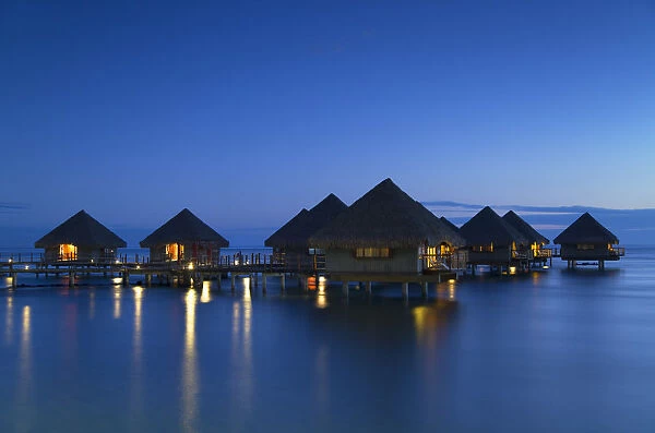Overwater bungalows at Le Meridien Tahiti Hotel at dusk, Pape ete, Tahiti