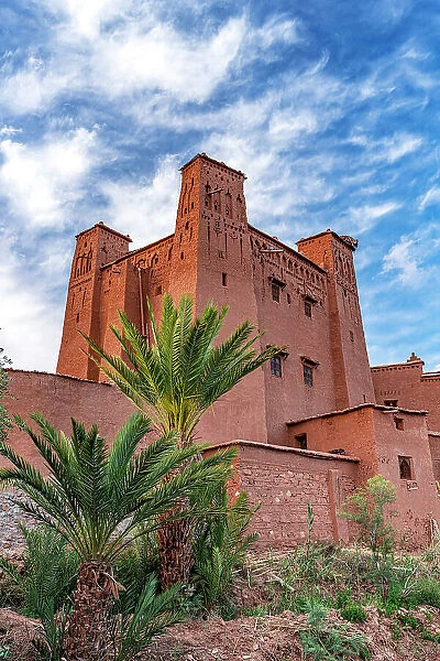 Palm trees framing the historic red mudbricks buildings in Ait Ben Haddou ksar, Ouarzazate province, Morocco