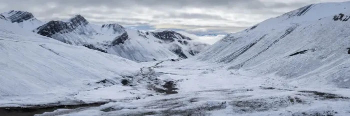 Framed Print : Panoramic view of trail leading through snow covered valley to Rainbow Mountain