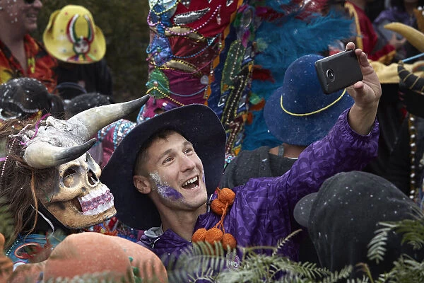 A participant of the Carnival in Uquia takes a 'selfie' with a 'devil', Jujuy, Argentina. Hundreds of devils descend from the 'Cerro Blanco' hill to celebrate the start of Carnival