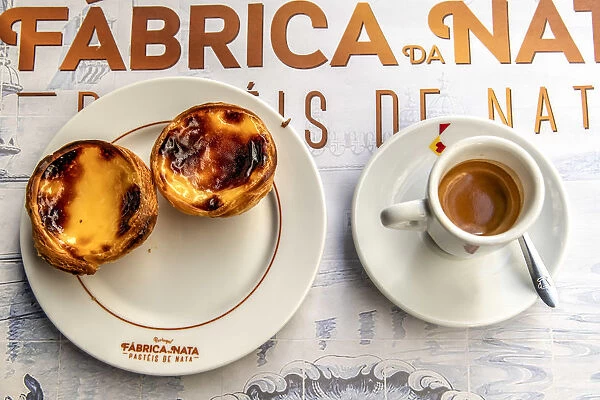 Pastel de belem or pasteis de nata custard tarts served with a cup of coffee in a
