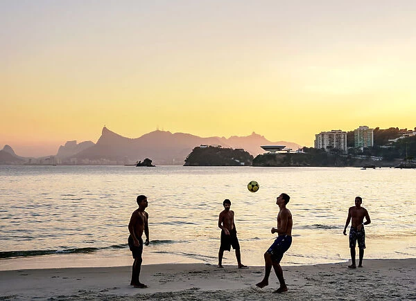 People playing football on Icarai Beach at sunset, Niteroi, State of Rio de Janeiro
