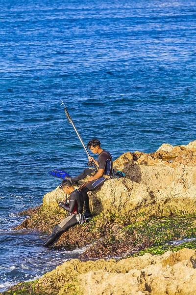 People spear fishing in the ocean off the Malecon, La Habana Vieja (Old Town), Havana