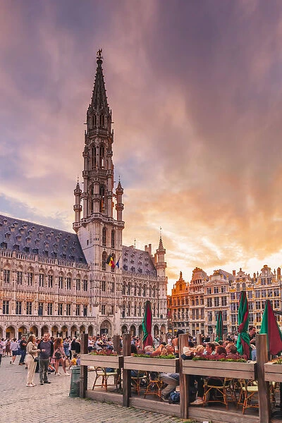 People walking and sitting in restaurants in the Grand Place in Brussels with the Town