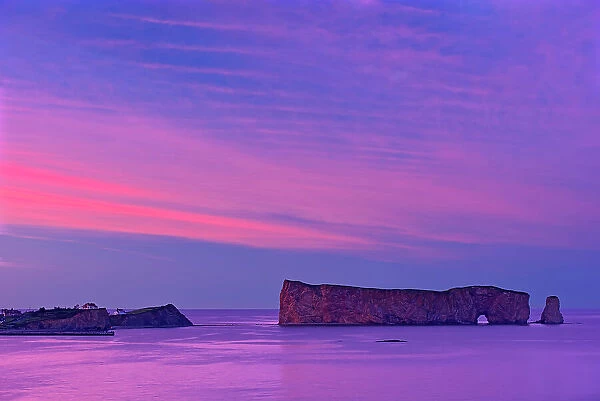Perce Rock, a masive rock formation in the Gulf of Saint Lawrence (Atlantic Ocean) on the tip of the Gaspe Peninsula. It is formed of reddish-gold limestone and shale. DAwn. Parc national de l'Ile-Bonaventure-et-du-Rocher-Perce