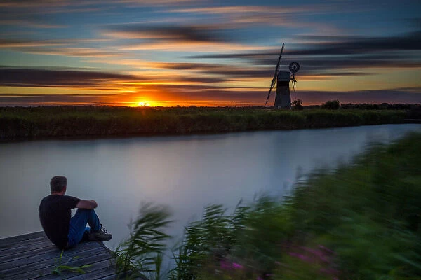 Person Enjoying Sunset by River Thurne, Norfolk Broads National Park, Norfolk, England
