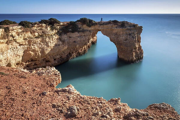 Person on Natural Sea Arch, Praia da Albandeira, Algarve, Portugal
