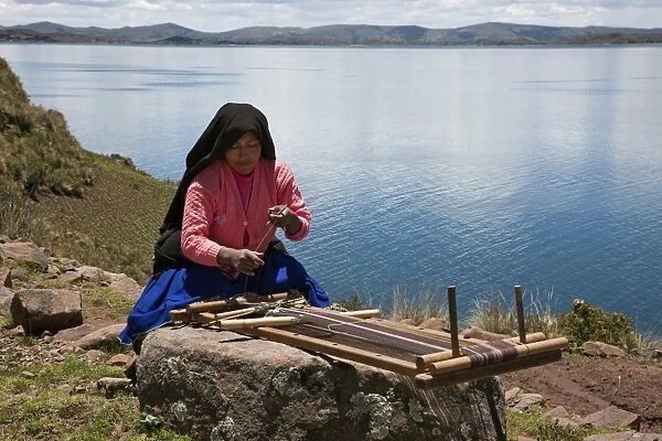 Peru, A Quechua-speaking woman works her traditional wooden loom on Taquile Island