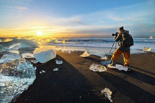 A photographer at Diamond Beach, Jokulsarlon, Diamond beach, Austurland, Iceland (MR)