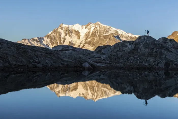 Framed Print : Photographer on rocks admiring Monte Rosa mirrored in water from Monte Moro Pass Framed Print : Photographer on rocks admiring Monte Rosa mirrored in water from Monte Moro Pass