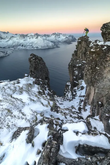 Framed Print : Photographer on the rocks on top of Mount Hesten admires the Mefjorden and the frozen Framed Print : Photographer on the rocks on top of Mount Hesten admires the Mefjorden and the frozen