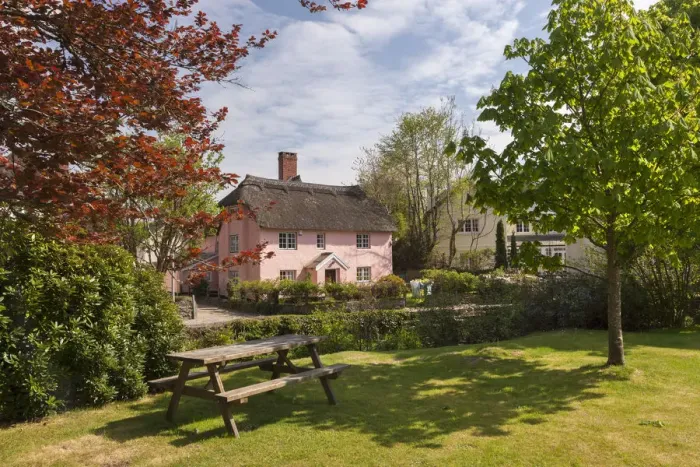 Framed Print : Picnic bench and pretty pink cottage in the village of Winsford, Exmoor National Park