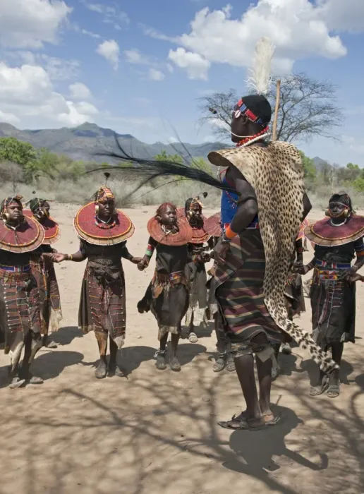Framed Print : A Pokot warrior wearing a cheetah skin jumps high in the air surrounded by young women to celebrate an Atelo ceremony. The Pokot are pastoralists speaking a Southern