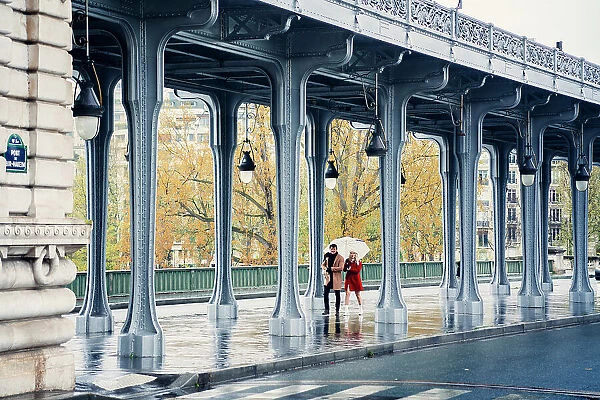 Pont de Bir Hakeim, bridge in Paris, France. Couple walking in a rainy day
