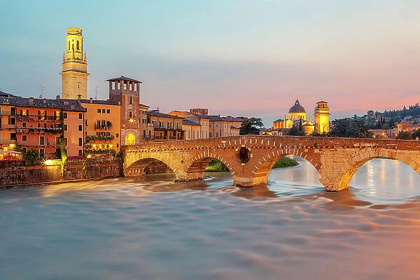 Ponte Pietra at dusk, with the bell tower of Verona Cathedral on the left and San Giorgio in Braida on the right. Verona, Veneto, Italy