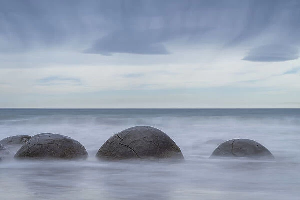 Popular Moeraki Boulders in sea against sky, Hampden, North Otago, South Island