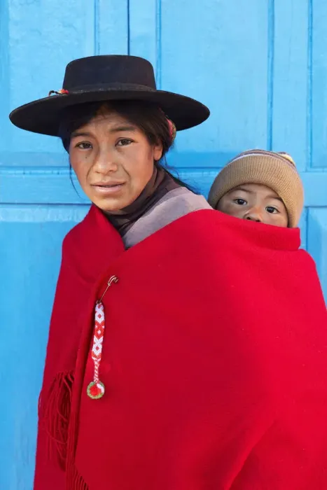 Framed Print : Portrait of an Aymara mother in traditional clothes with her child standing in front of