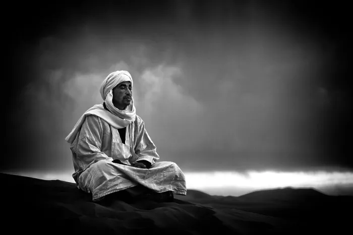 Framed Print : Portrait of a Berber man wearing traditional Djellaba and cheche (headscarf), sitting on a sand dune, Sahara Deseret, near, Merzouga Morocco