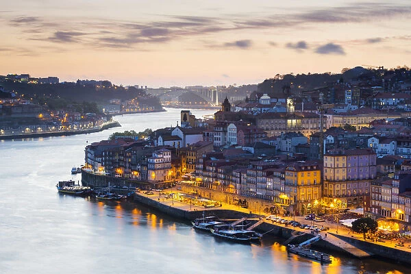 Portugal, Douro Litoral, Porto. Dusk in the UNESCO listed Ribeira district, viewed