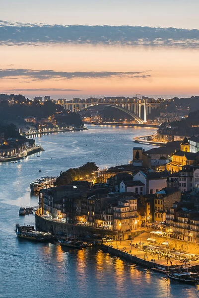 Portugal, Norte region, Porto (Oporto). Douro river banks at dusk with Arrabida bridge