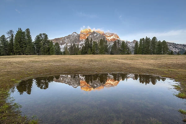 Prato Piazza / Pl√§tzwiese, Dolomites, South Tyrol, Italy. The Croda Rossa d'Ampezzo is reflected at sunrise in a pool on the Prato Piazza