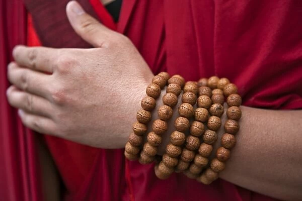 Prayer beads wrapped round the wrist of a red-robed monk near Mongar. There is a special religious significance in having exactly 108 beads in