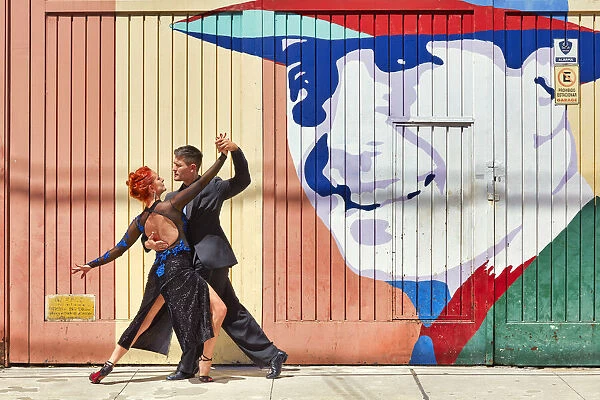 Professional Tango Dancers in front of a wall art of the historical tango artist Carlos Gardel in the Abasto neighborhood, Buenos Aires, Argentina. (MR)