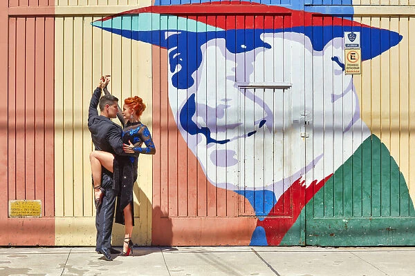 Professional Tango Dancers in front of a wall art of the historical tango artist Carlos Gardel in the Abasto neighborhood, Buenos Aires, Argentina. (MR)