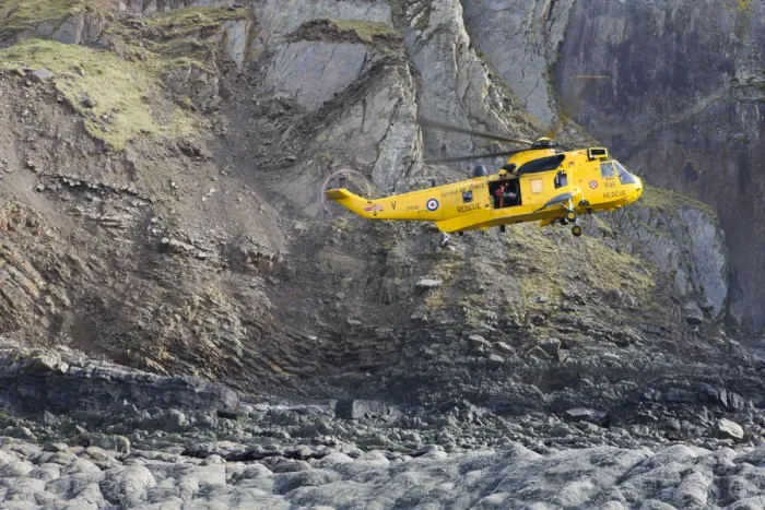 Framed Print : RAF helicopter performing a coastal rescue at the base of the steep cliffs of Spekes Framed Print : RAF helicopter performing a coastal rescue at the base of the steep cliffs of Spekes