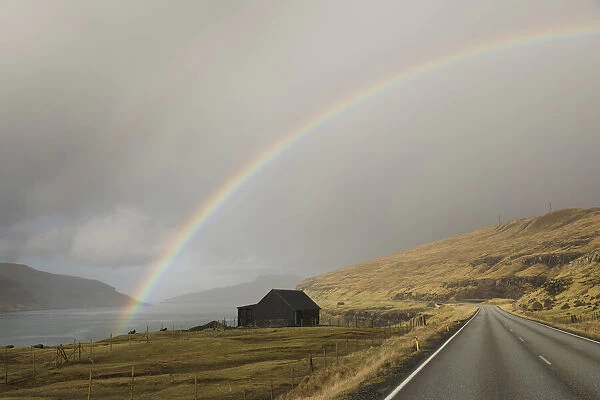 A rainbow over a sheep house on the Sundini strait between the islands of Eysturoy and Streymoy. Faroe Islands